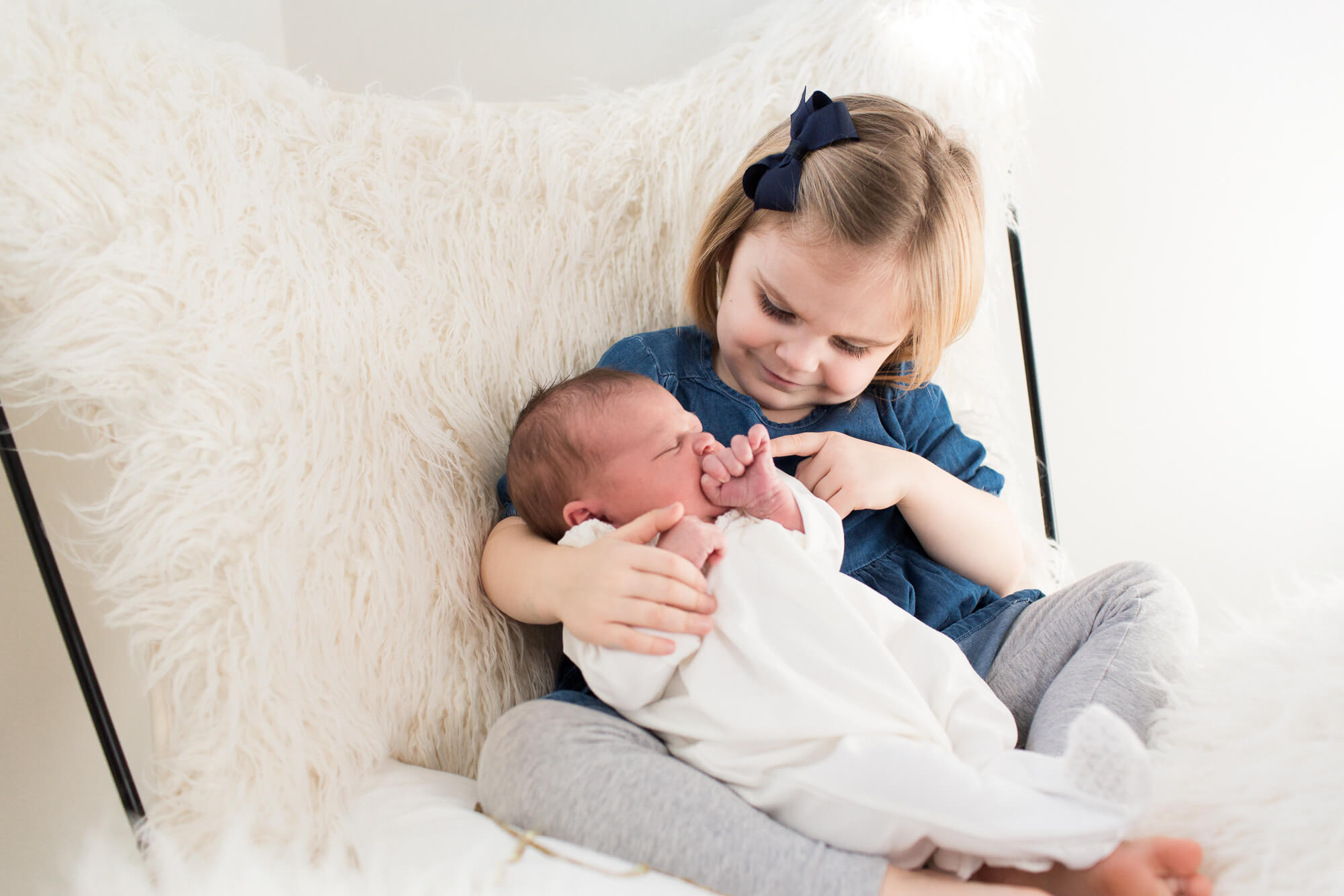 big sister holding new addition | oahu family hawaii newborn in home lifestyle session with elle rose photo | kailua big sister new baby stylish house 