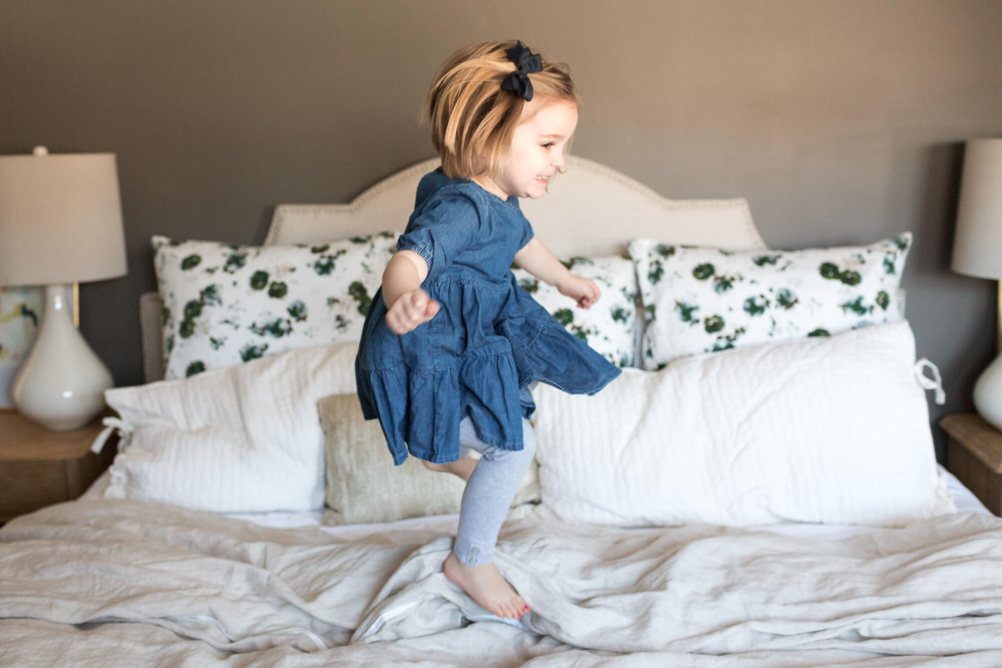 girl jumping on bed | oahu family hawaii newborn in home lifestyle session with elle rose photo | kailua big sister new baby stylish house 