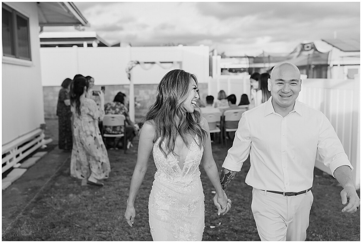 newly married bride and groom walk back up the aisle  for pearl city backyard celebration